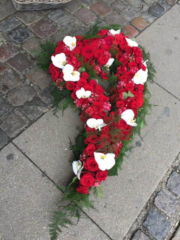 Stort blomster hjerte med hul i midten i røde og hvide blomster.